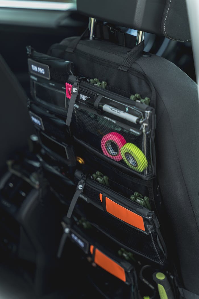 A multi-pocket car seat back organizer with colorful accessories for convenient storage.