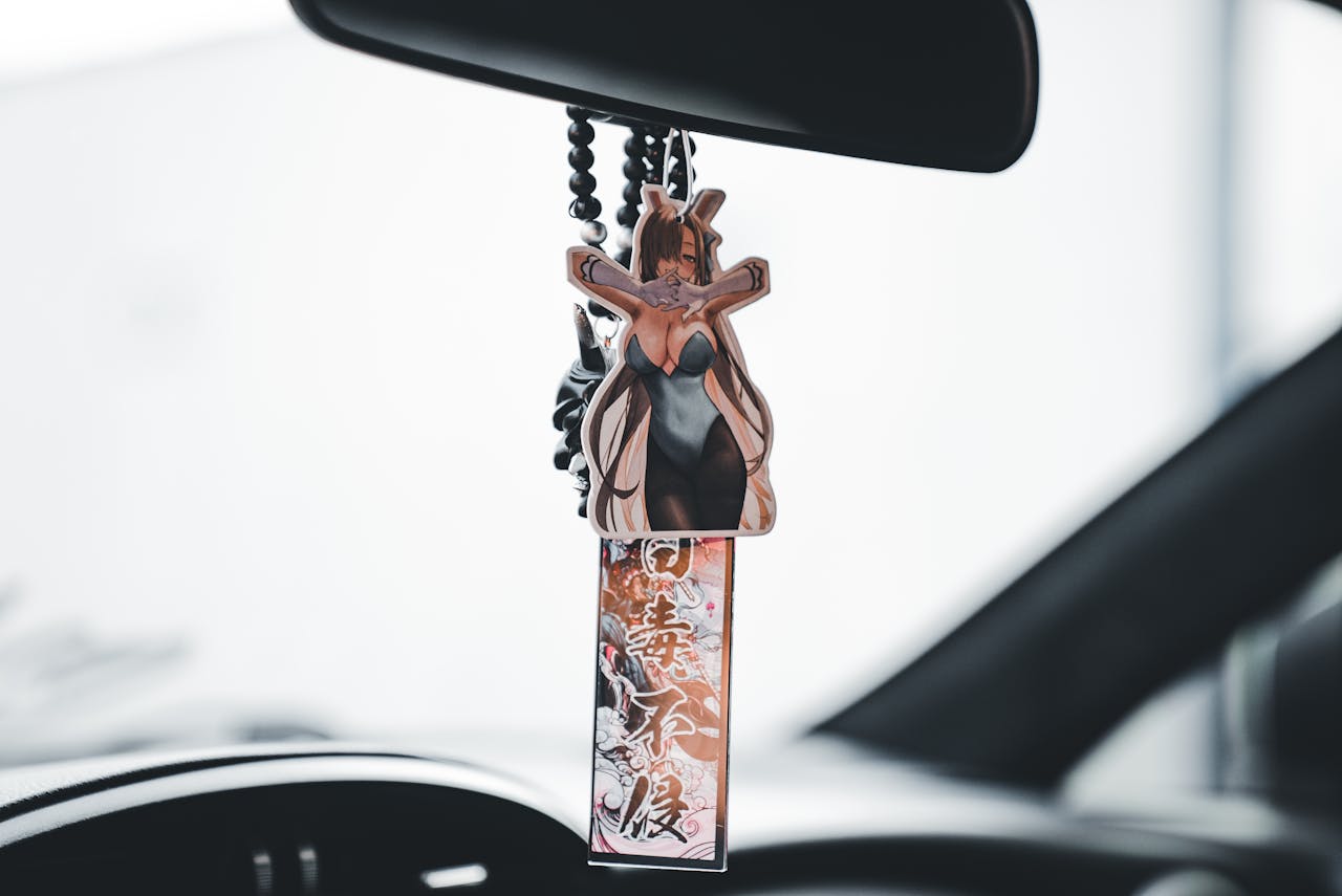 Anime-themed car ornament featuring a character, creating a stylish and unique interior look.